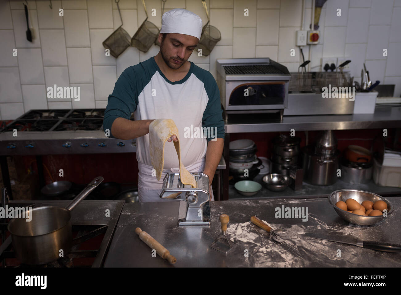 Baker using machine for preparing pasta Stock Photo