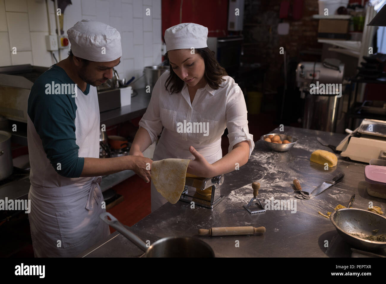Bakers using machine for preparing pasta Stock Photo