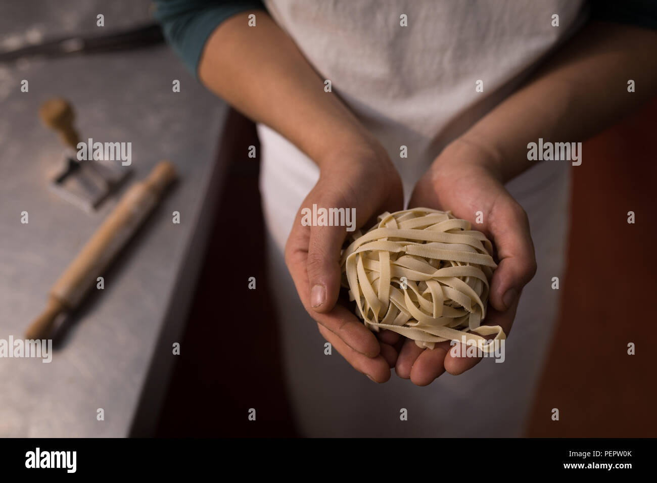 Baker holding tagliatelle in a hand Stock Photo