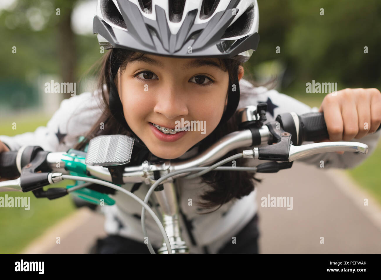 Girl riding bicycle on street Stock Photo