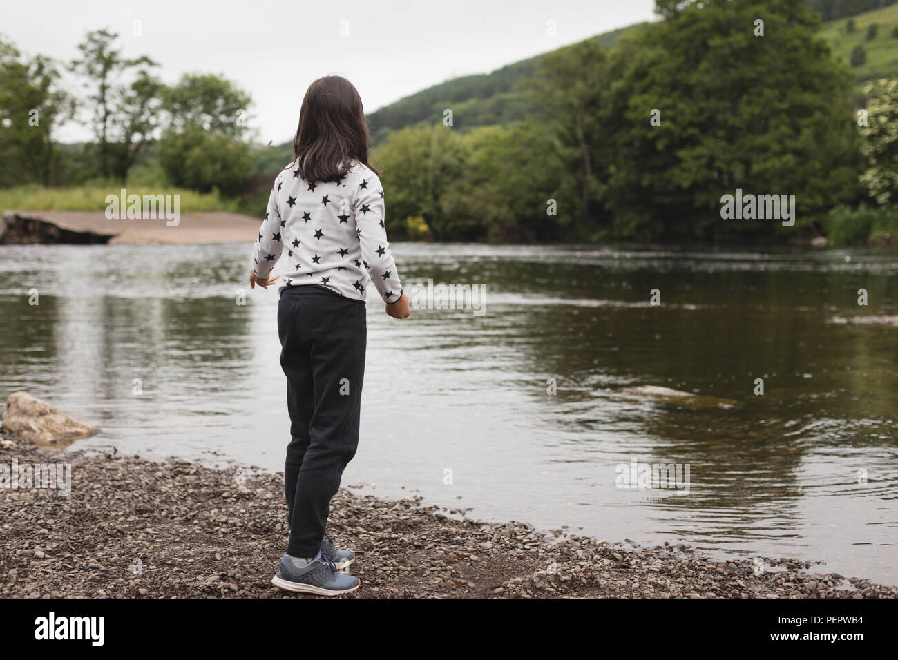 Girl standing near riverside Stock Photo