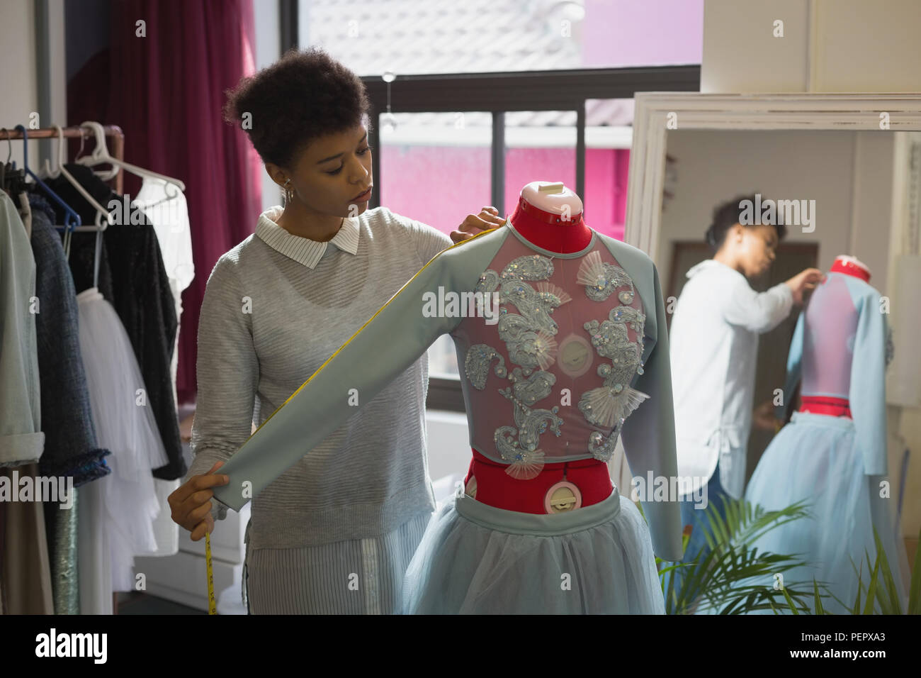 Fashion designer taking measurement of mannequin Stock Photo Alamy