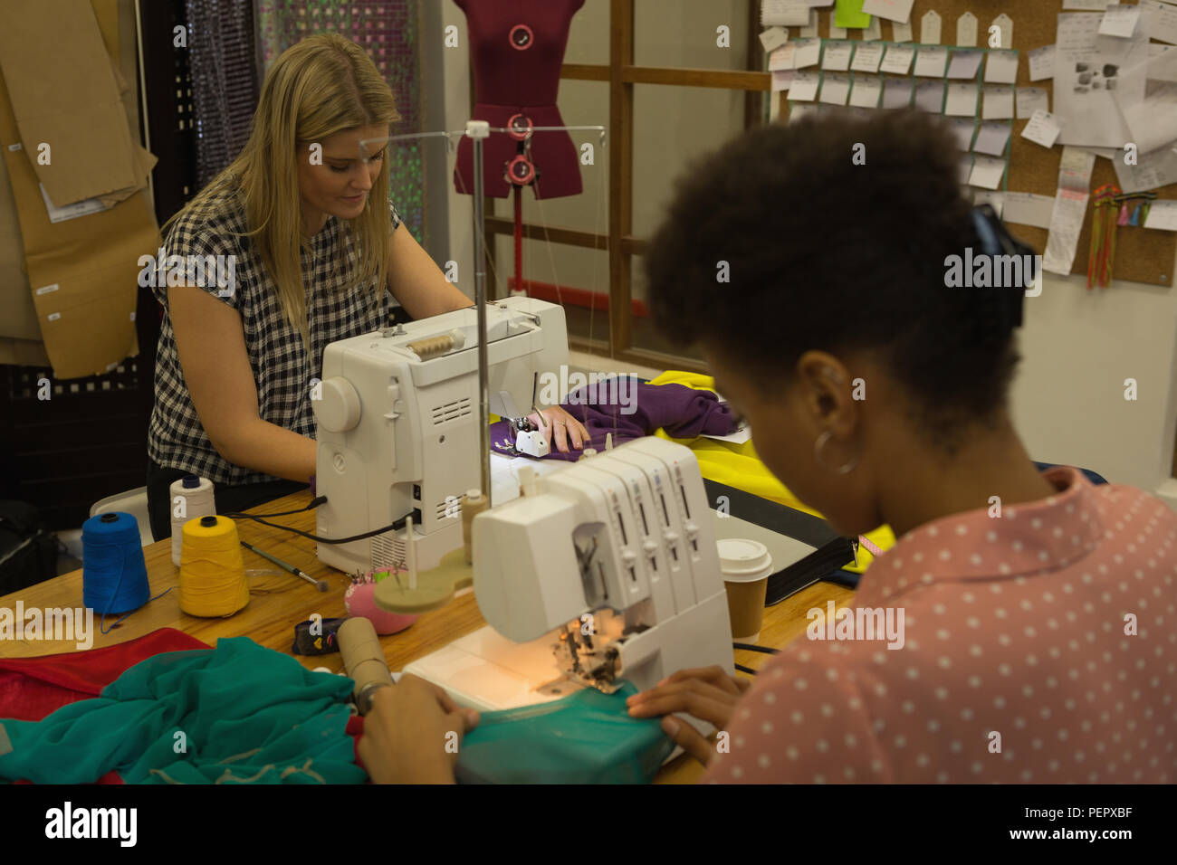Fashion designers using sewing machine Stock Photo Alamy