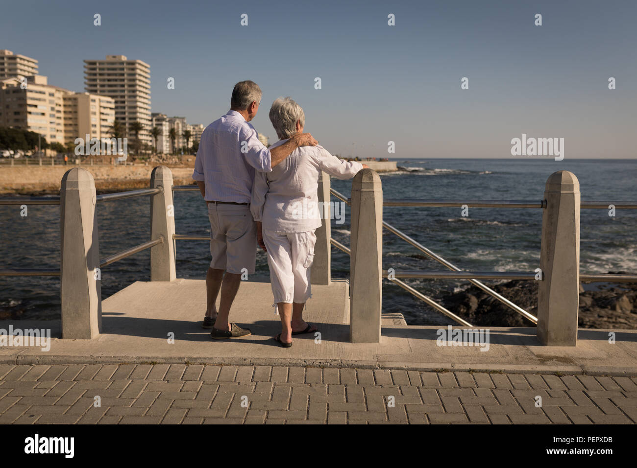 Senior couple standing near sea side at promenade Stock Photo