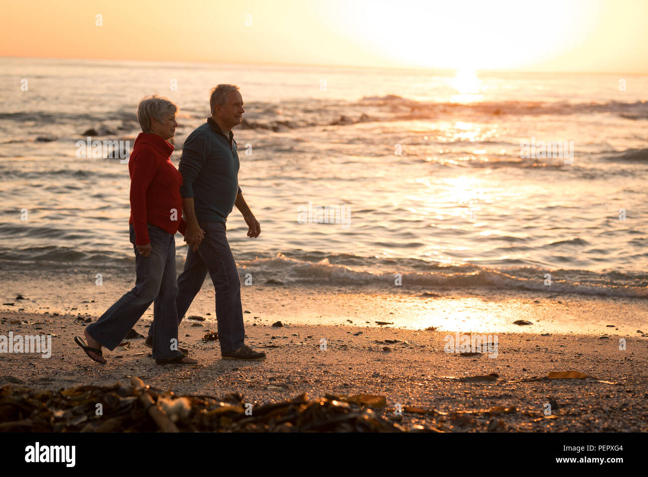 Senior couple walking on beach Stock Photo