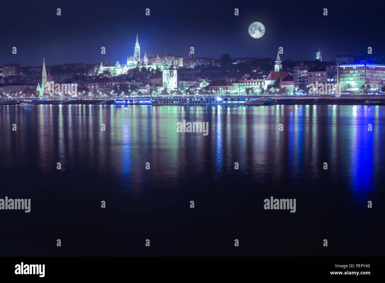 Night view in blue hue of the Pest side of Budapest across the Danube River in Hungary, Europe with full moon Stock Photo
