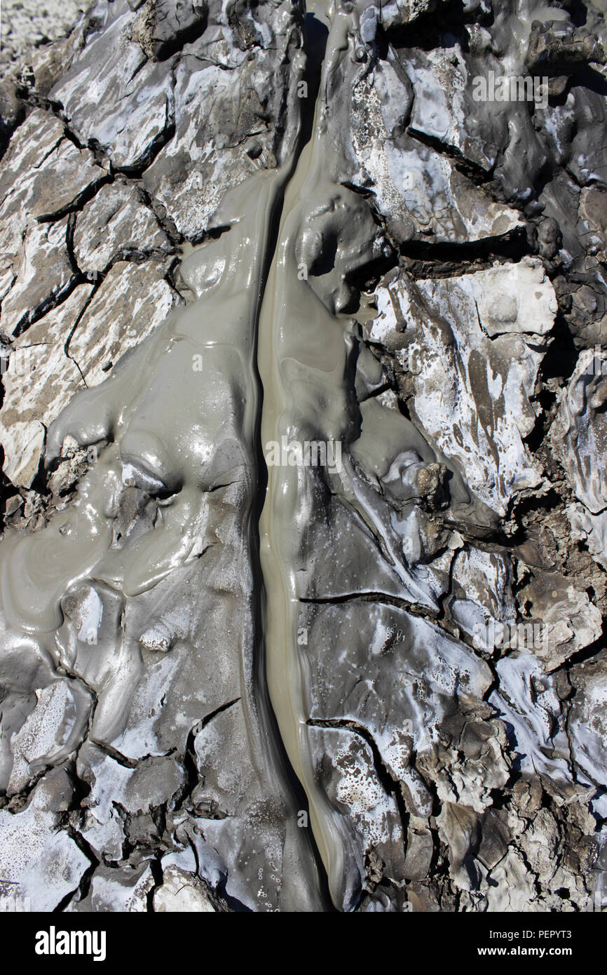 texture of the earth's surface and cracks next to the cold mud volcano. The layer of mud, which volcano erupts, quickly dries up and cracks covering w Stock Photo