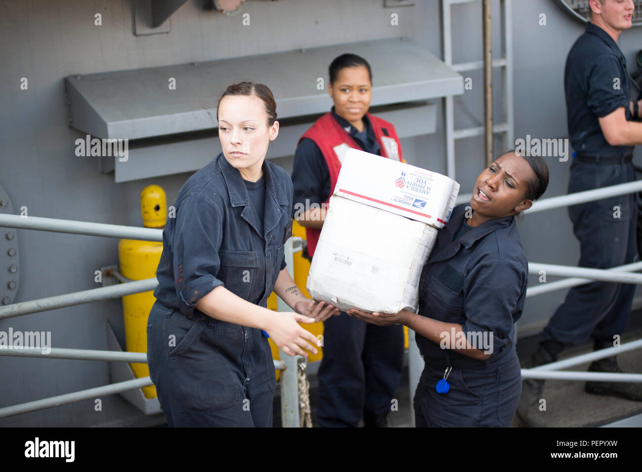 160114-N-JO245-262 GULF OF OMAN (Jan. 14, 2016) Boatswain’s Mate Seaman Caitlyn Duxbury, from Ripon, Calif., (left) and Seaman Robin Kirkland-Jefferson, from New Orleans, pass boxes of mail aboard the dock landing ship USS Oak Hill (LSD 51), during a replenishment at sea with the Military Sealift Command dry cargo and ammunition ship USNS Richard E. Byrd (T-AKE 4). Oak Hill is part of the Kearsarge Amphibious Ready Group (ARG) and, with the embarked 26th Marine Expeditionary Unit (MEU), is deployed in support of maritime security operations and theater security cooperation efforts in the U.S.  Stock Photo