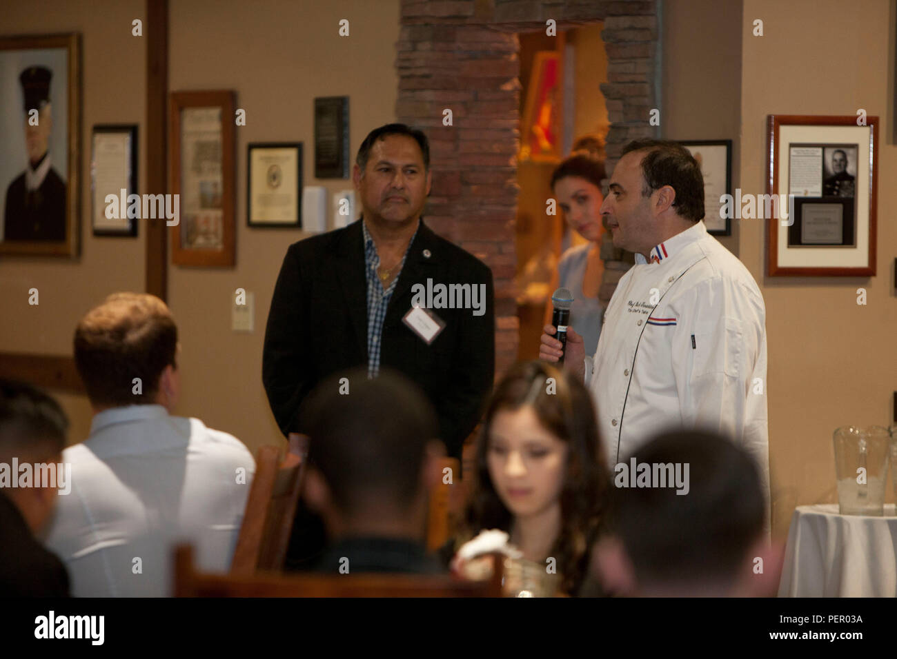 Mr. Paul Chapa (left), founder of Food Industry Feeding Heros (FISH), and celeberity chef Rick Tarantino (right) speak with honored guests prior to the start of the FISH dinner, at Iron Mike's lounge on Camp Pendleton, Calif., Jan 21, 2016. The event is hosted by Camp Pendleton and MCIWEST Commanding General, Brig. Gen. Edward Banta, and Mr. Paul Chapa to honor service members for their accomplishments and sacrifices. (U.S. Marine Corps photo by Cpl. Brian Bekkala/MCIWEST-MCB CamPen Combat Camera/Released) Stock Photo