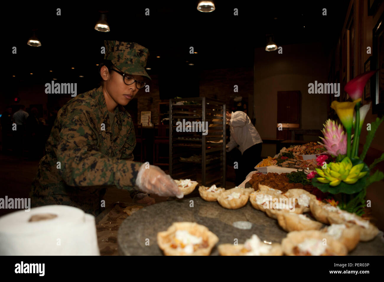 U.S. Marine Corps GySgt. Jessica Lee, Battalion Mess Chief, with Combat Logistics Battalion 13, 13th Marine Expeditionary Unit, places appetizers on the table, at Iron Mike’s lounge on Camp Pendleton, Calif. prior to the start of the Food Industry Feeding Heroes (FISH) dinner, Jan 21, 2016. The event is hosted by Camp Pendleton and MCIWEST Commanding General, Brig. Gen. Edward Banta, and Mr. Paul Chapa to honor service members for their accomplishments and sacrifices.  (U.S. Marine Corps photo by Cpl. Brian Bekkala/MCIWEST-MCB CamPen Combat Camera/Released.) Stock Photo