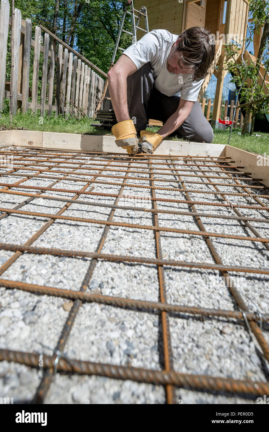 Single Worker In Thick Gloves Installing Iron Rods For Concrete
