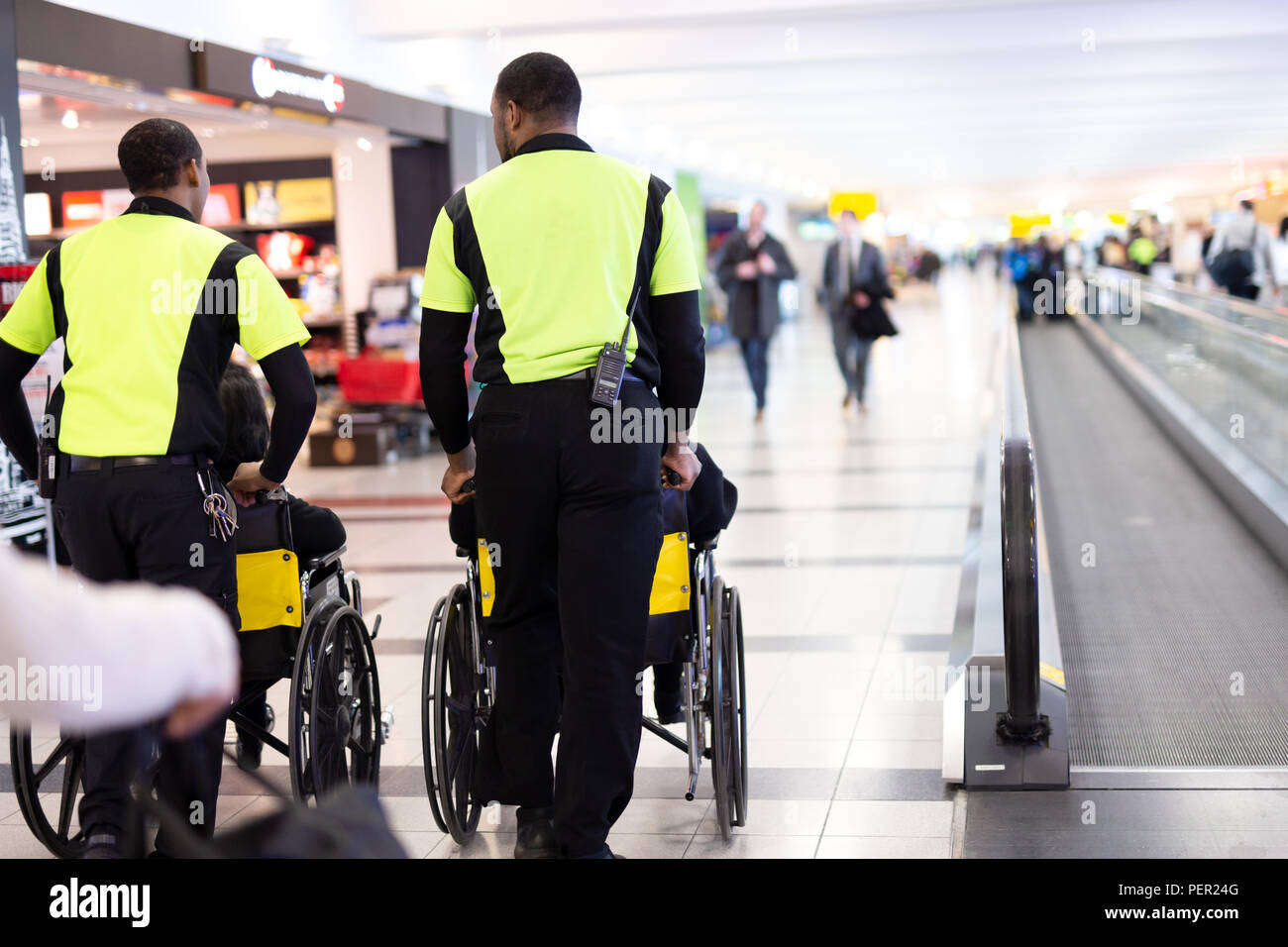 Man caretaker pushing elderly people in wheelchair in the airport. Stock Photo