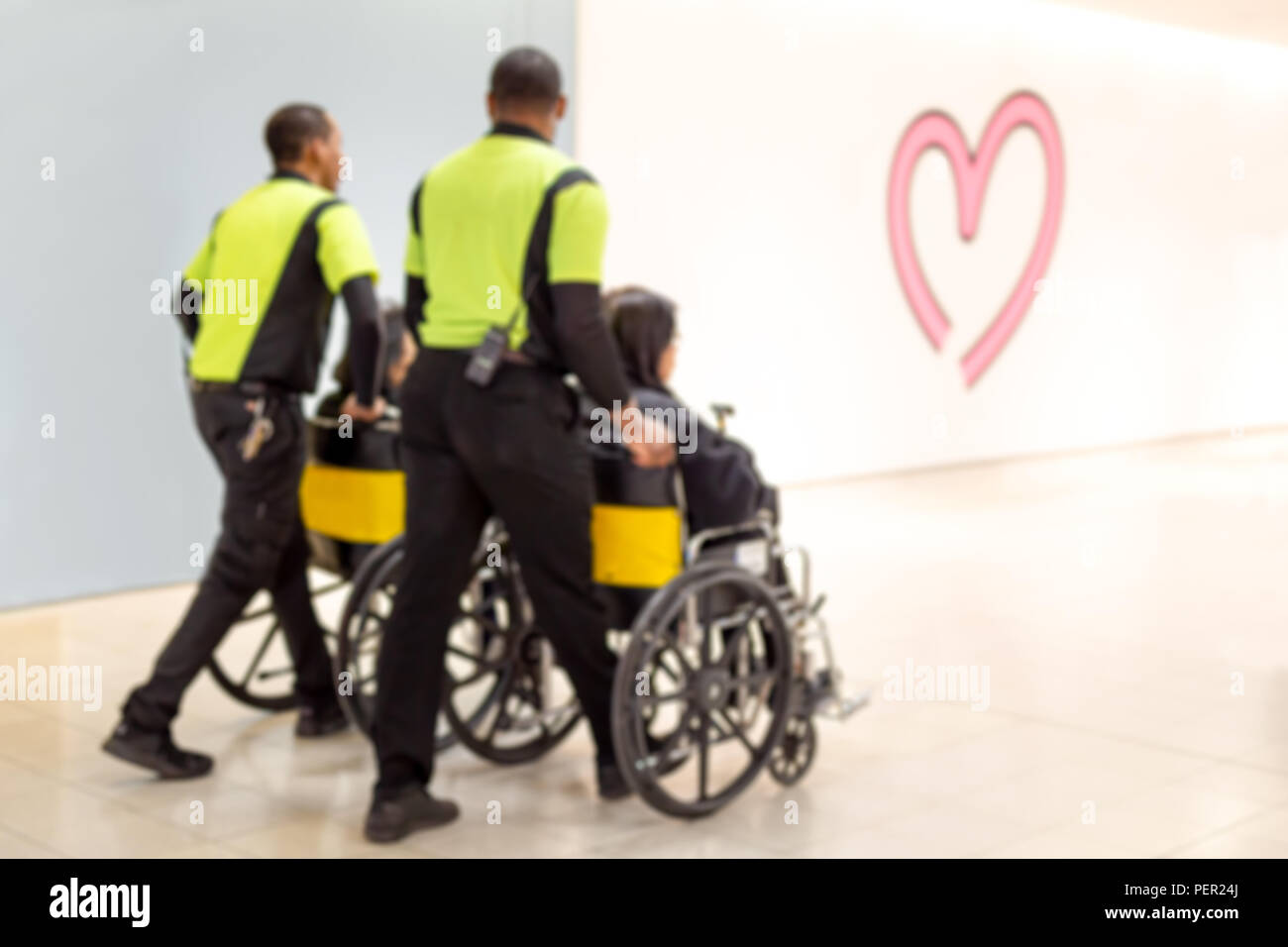 Blurred concept caretaker pushing elderly people in wheelchair in the airport. Stock Photo