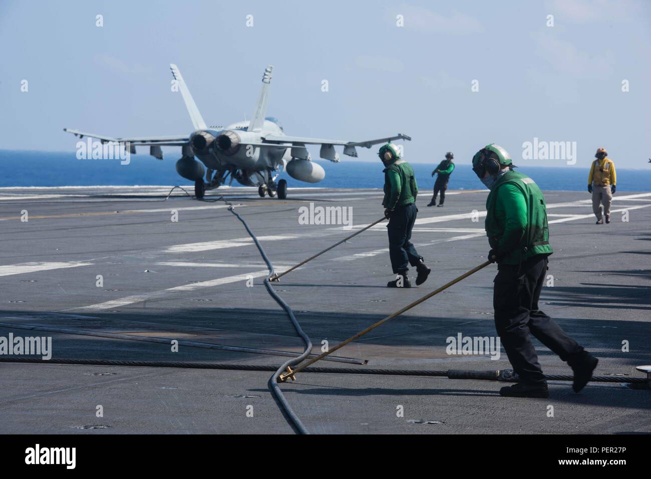 160130-N-GZ947-083 PACIFIC OCEAN (Jan. 30, 2016) - Aviation Boatswain's Mate  (Equipment) Airman Alex Fernau, from St. Jospeph, Mich., and Aviation  Boatswain's Mate (Equipment) Airman Hayden East, from Lake Charles, La.,  guide an