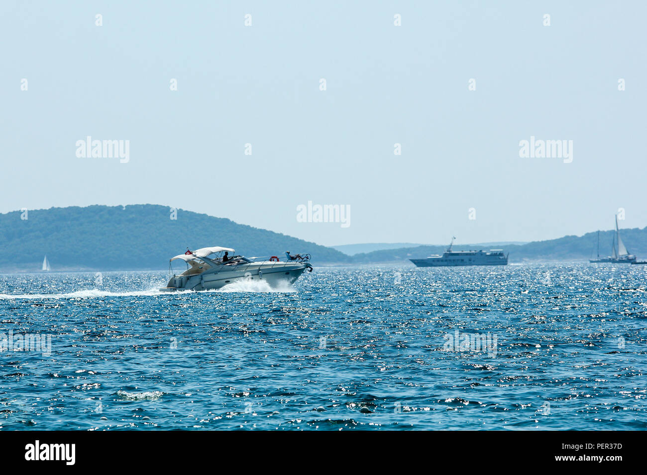 A picture of several boats floating on the blue ocean during the hot summer day. Relaxing vacation activity for the people. Stock Photo