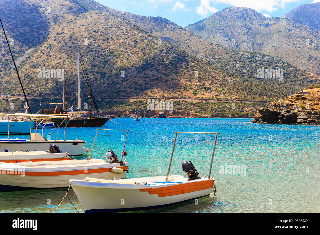 small fishing boats at pier in fishing village Bali with mountains at background in Crete, Greece Stock Photo