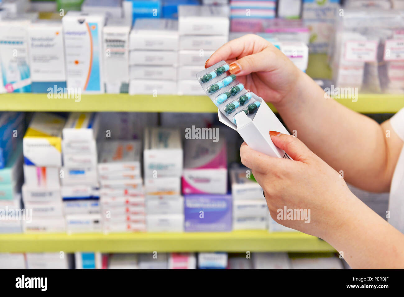 Hand holding medicine capsule pack at the pharmacy drugstore. Stock Photo