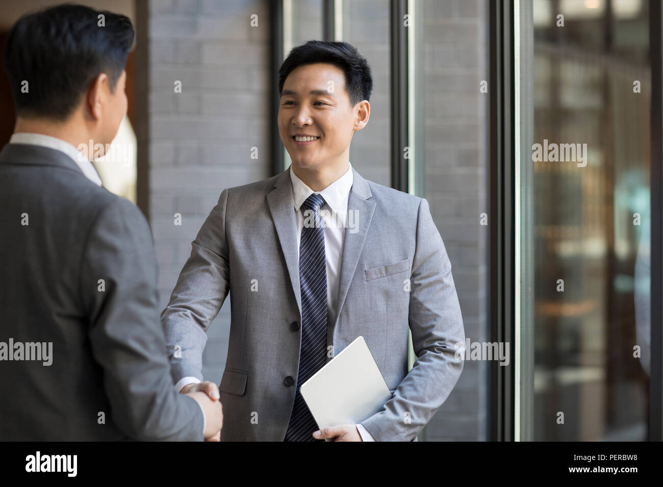 Cheerful businessmen shaking hands Stock Photo
