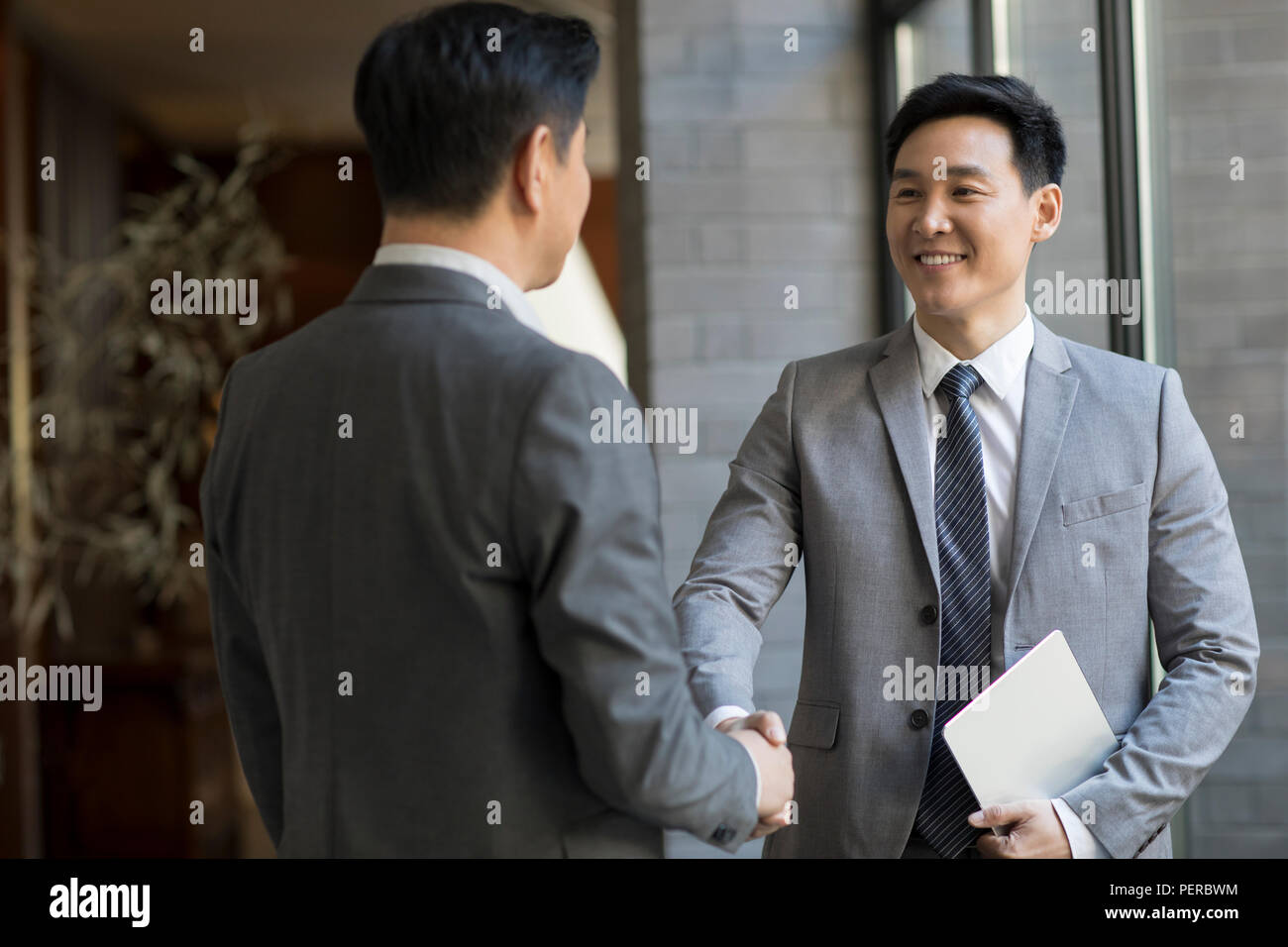Cheerful businessmen shaking hands Stock Photo