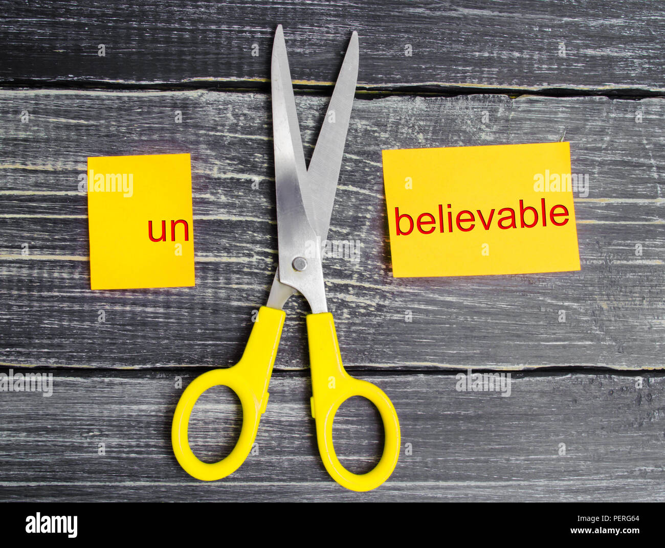 scissors cut the word unbelievable. concept believable. cuts the word "un. "I can, goal