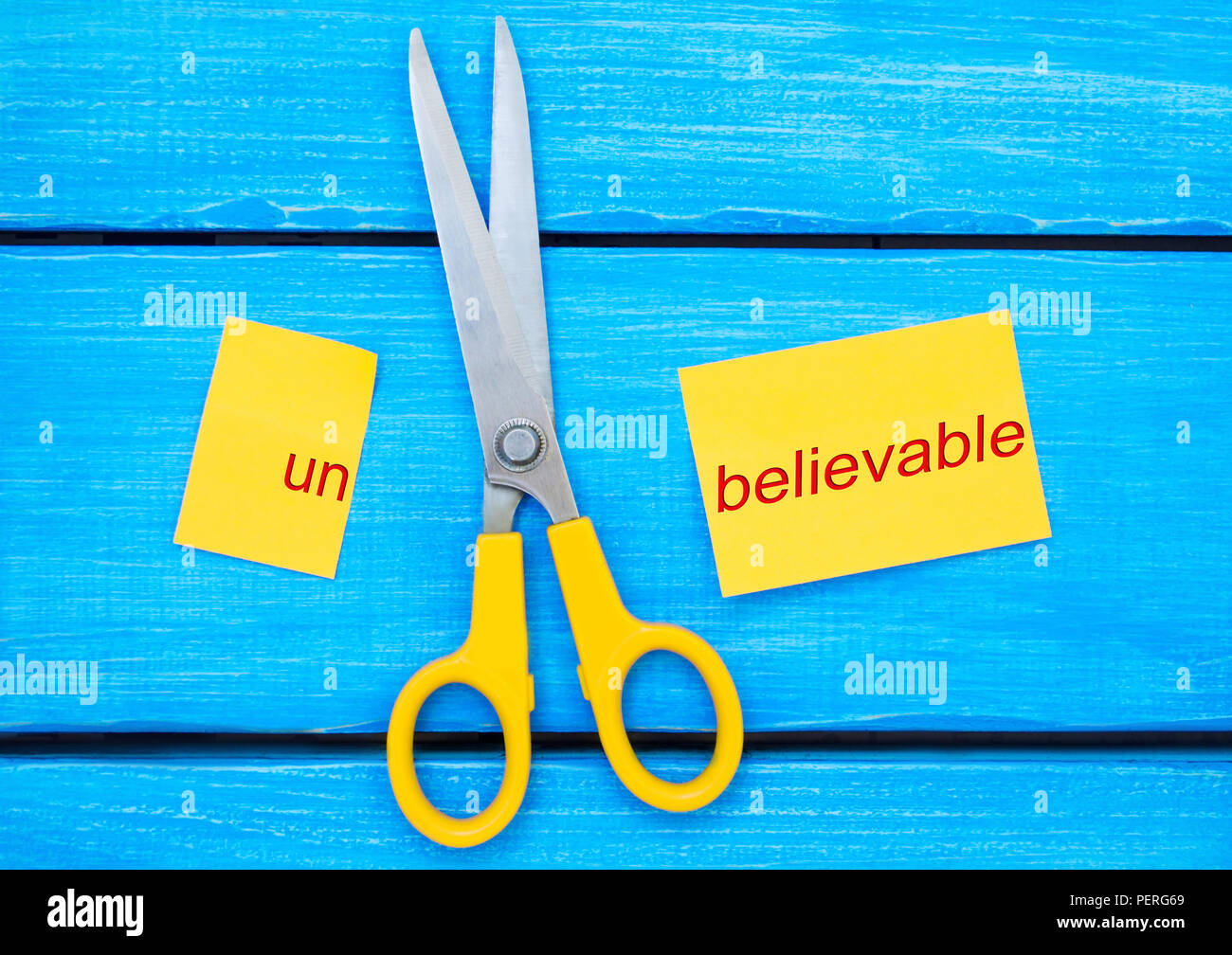 scissors cut the word unbelievable. concept believable. cuts the word
