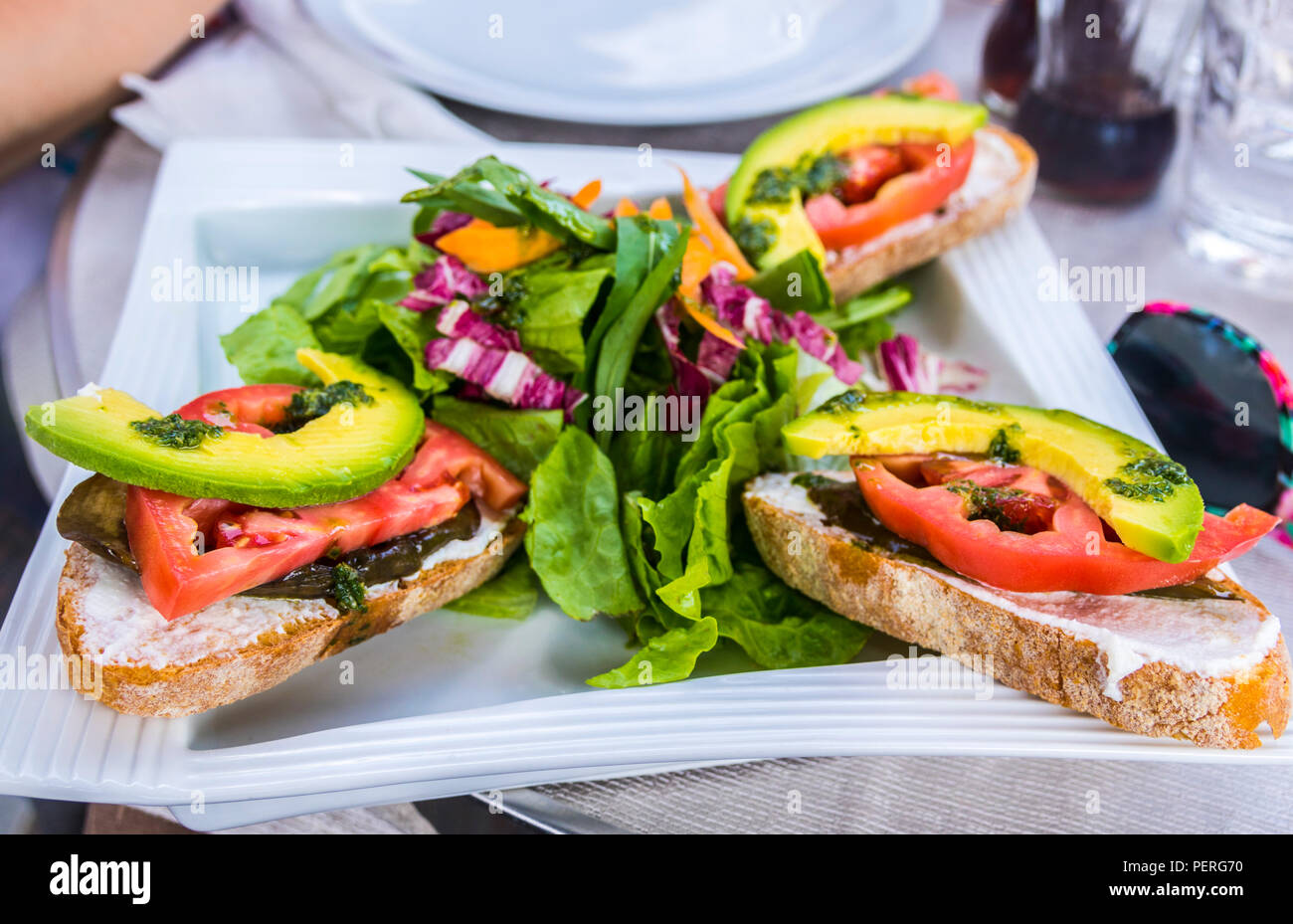 caprese starter, tomato basil avocado, crusty bread, greens, salad, eating al fresco, Italy, Europe Stock Photo