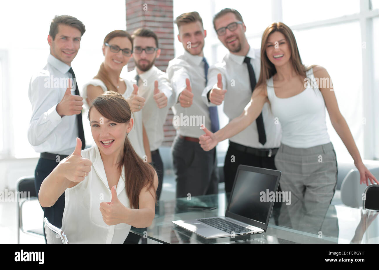 smiling business team showing thumbs up Stock Photo - Alamy