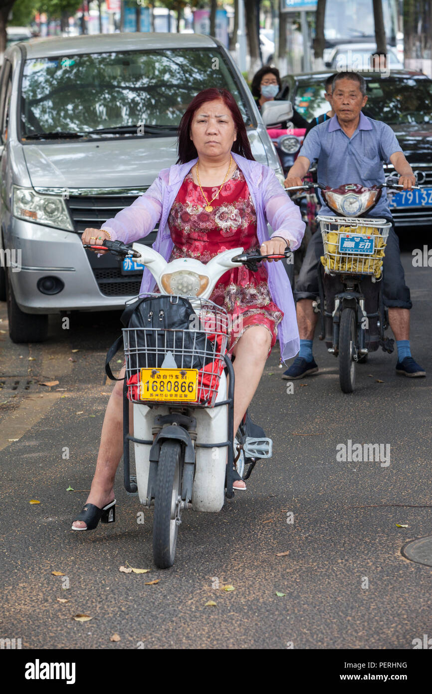 Suzhou, Jiangsu, China.  Middle-aged Man and Woman on their Motorbikes. Stock Photo