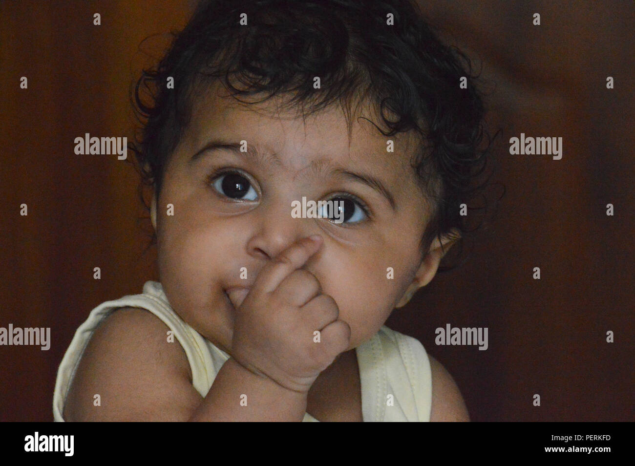 Infant's close up of am adorable very expressive big eyed cute Indian's delightful face a real treasure and pleasure to look at. Stock Photo