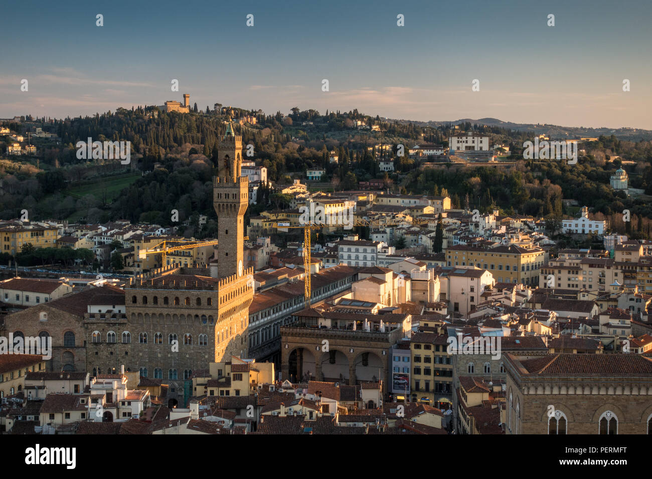 Florence, Italy - March 23, 2018: Evening light illuminates the cityscape of Florence, including the landmark tower of Palazzo Vecchio, with the Arcet Stock Photo
