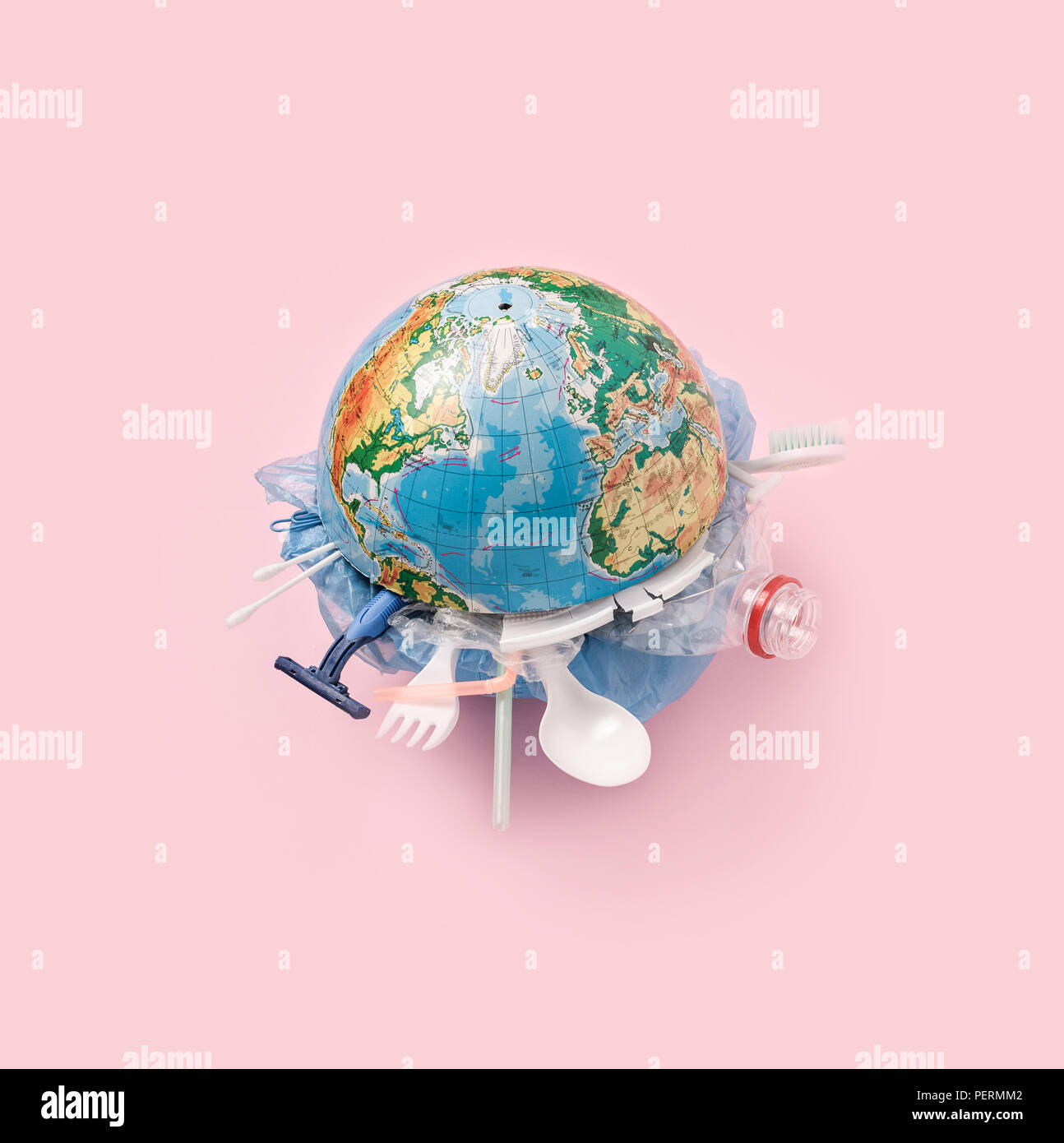The globe and global pollution by plastic. Globe and plastic household items. Stock Photo