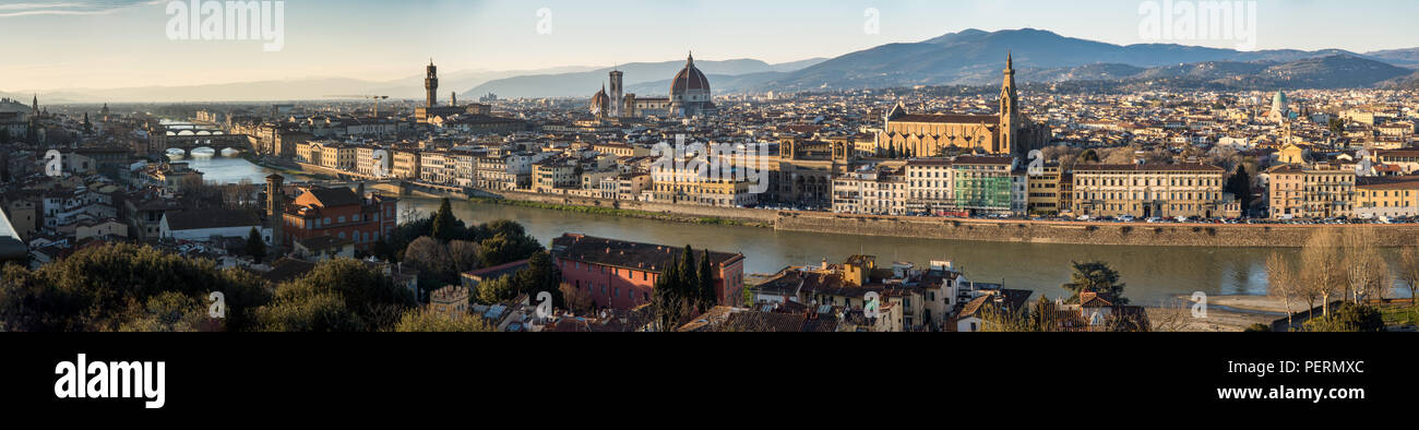 Florence, Italy - March 23, 2018: Evening light illuminates the cityscape of Florence along the Arno River, including the landmark Ponte Vecchio bridg Stock Photo