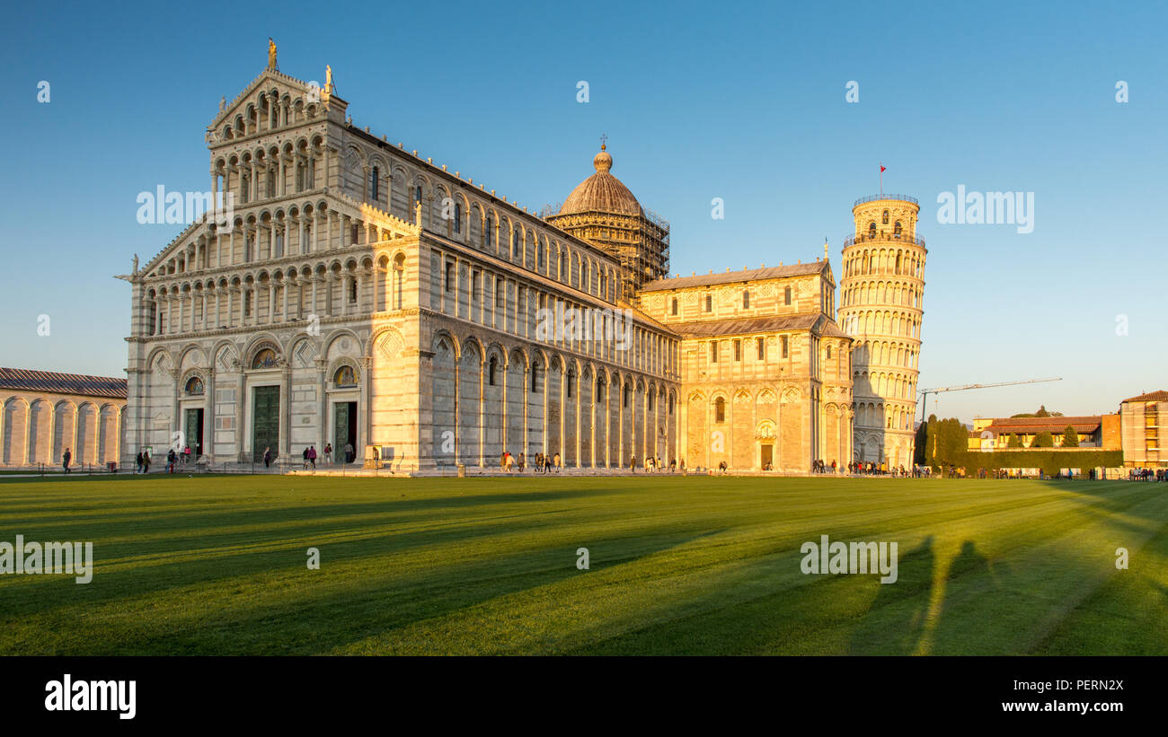 Pisa, Italy - March 21, 2018: Evening sun shines on the iconic Leaning Tower of Pisa beside the Duomo Cathedral. Stock Photo