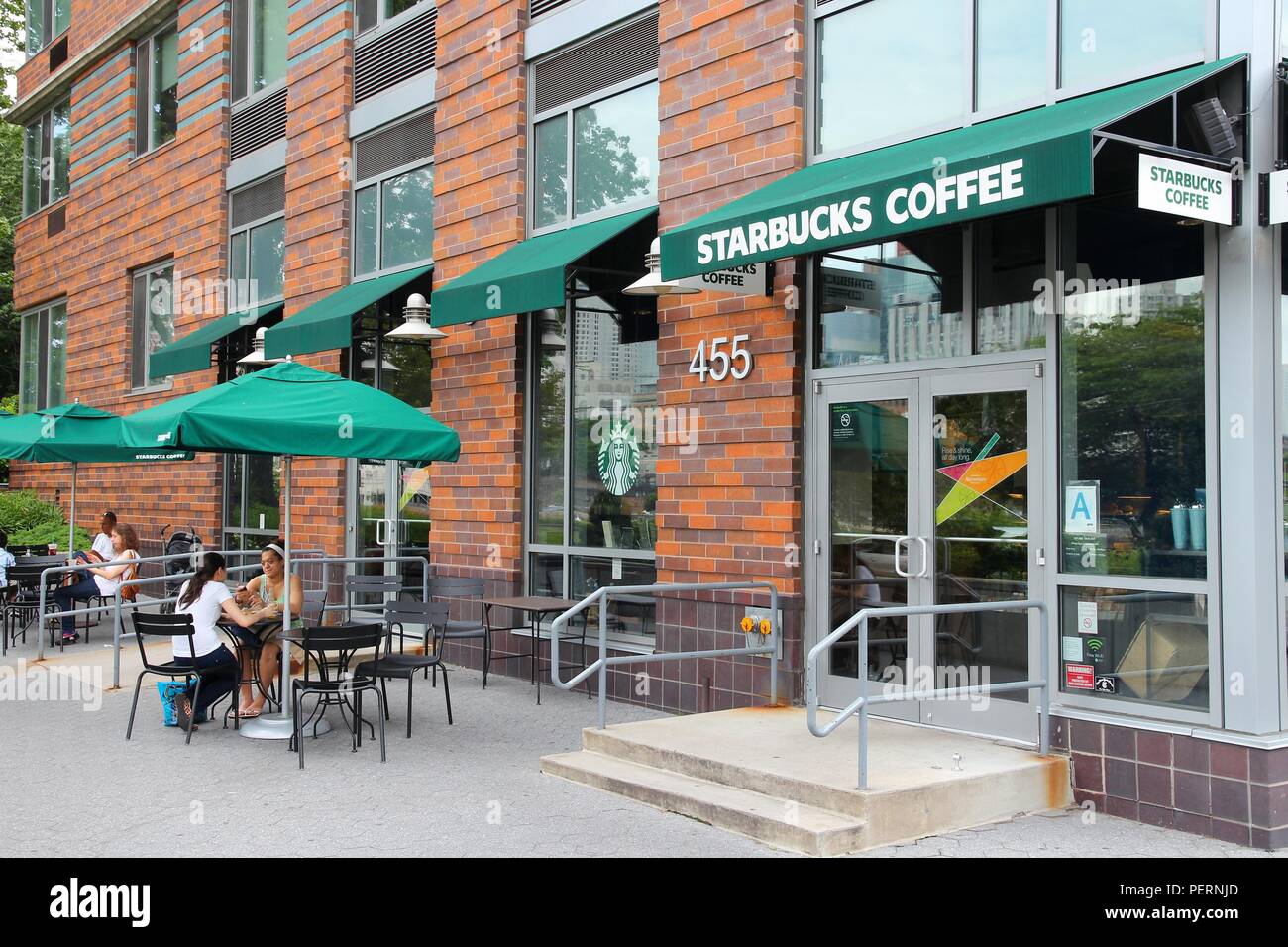 NEW YORK - JULY 3: People visit Starbucks Coffee shop on July 3, 2013 in New York. Starbucks is the largest coffee house company in the world, it has  Stock Photo