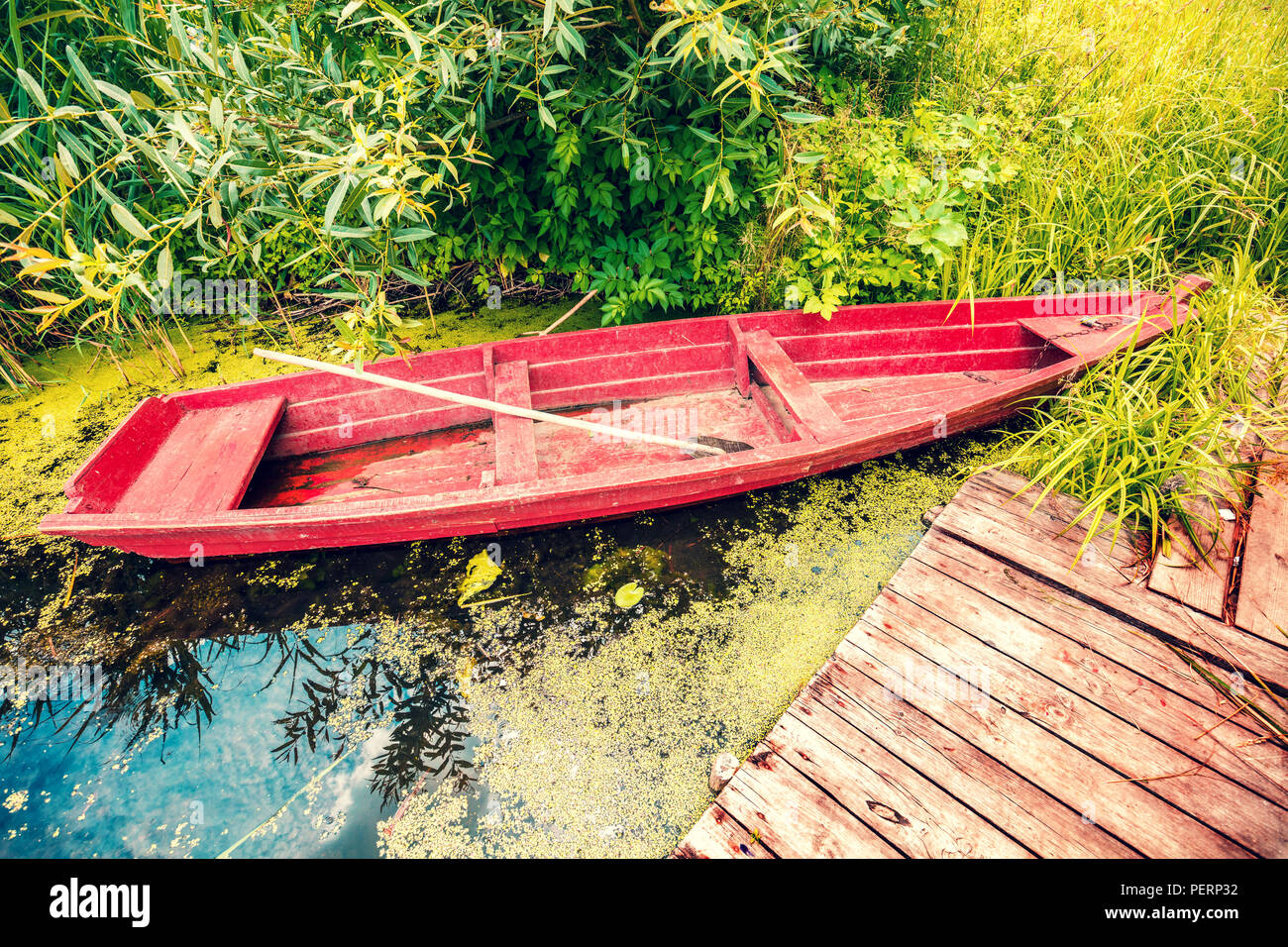 Wooden boat on the river bank at the wooden pier Stock Photo - Alamy