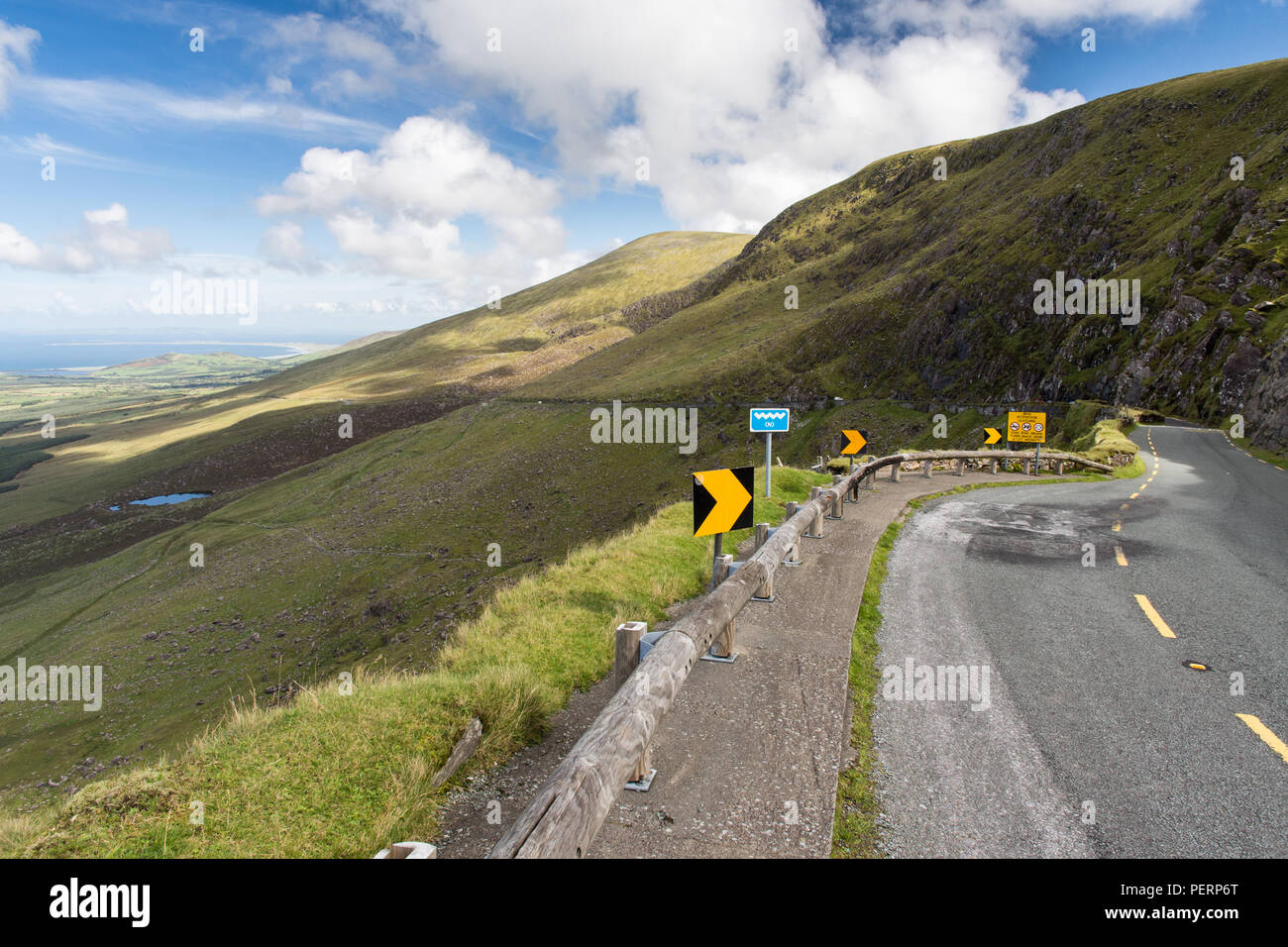 Touring motorists cross the mountains of Ireland's Dingle Peninsula on the narrow winding Conor Pass road. Stock Photo