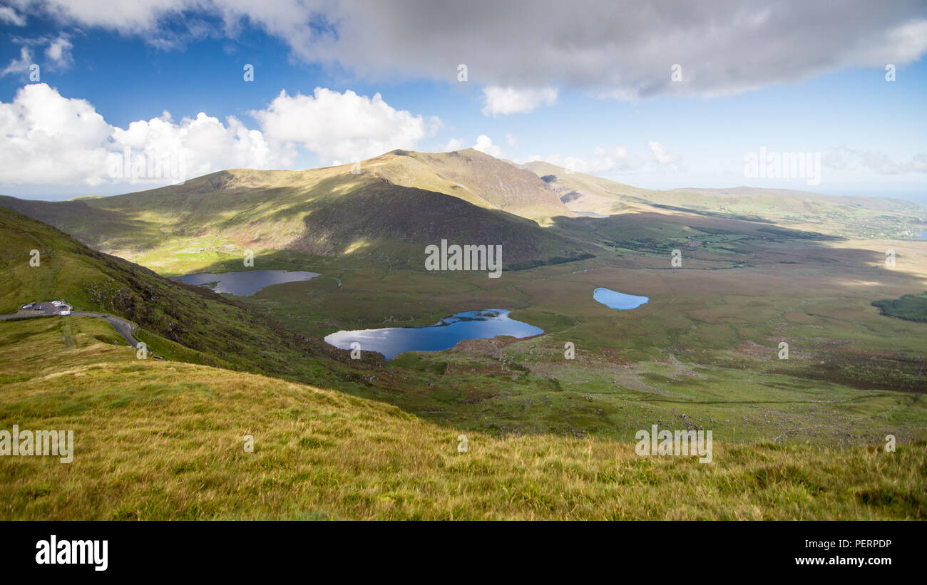 Brandon Mountain rises above the lakes of the Owenmore Valley forming the spectacular view from the summit of the Connor Pass through the mountains of Stock Photo