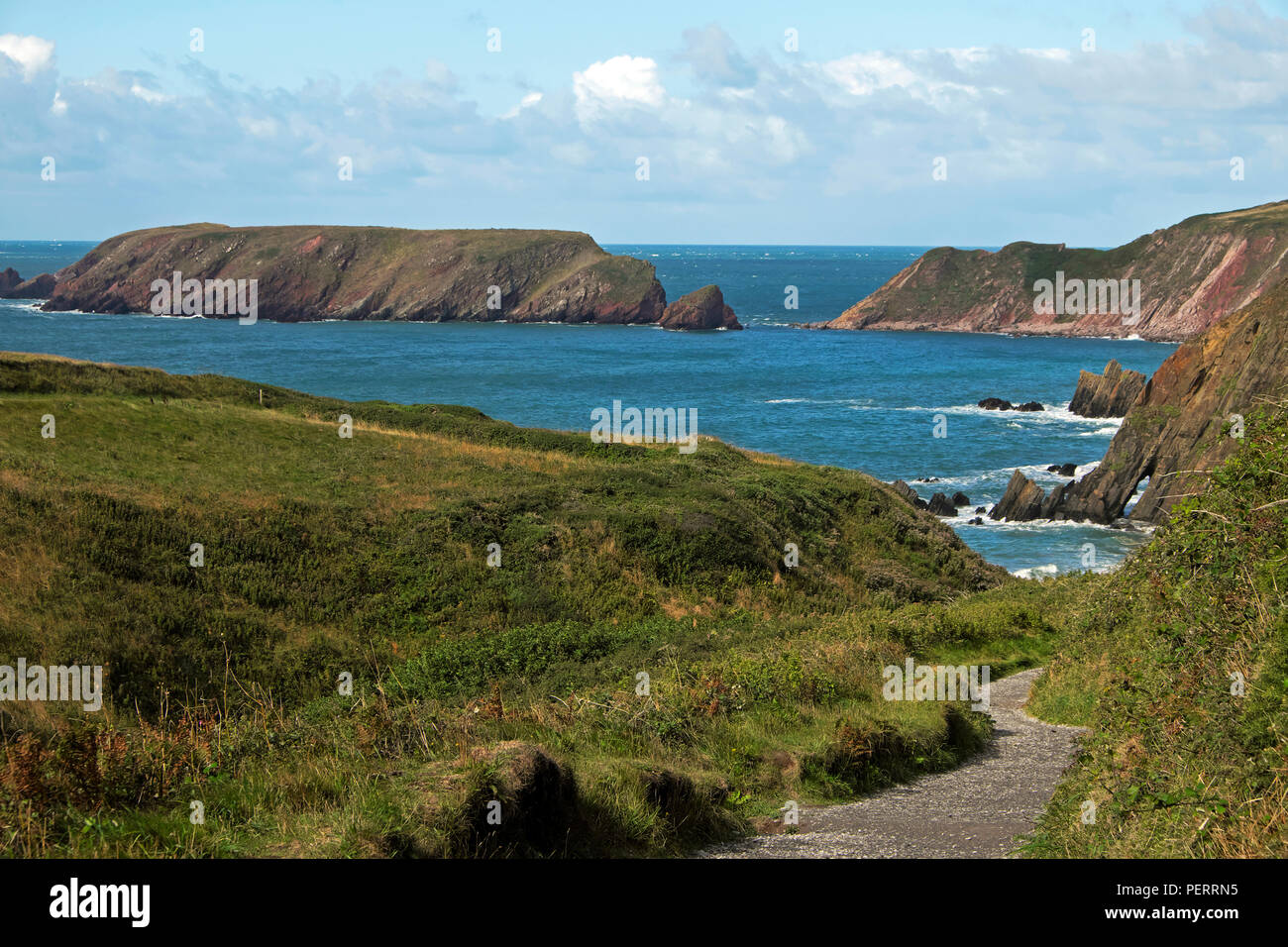 View of path leading to Marloes Sands beach, Wales Coastal Path and Gateholm Island at high tide in Pembrokeshire Coast West Wales UK  KATHY DEWITT Stock Photo