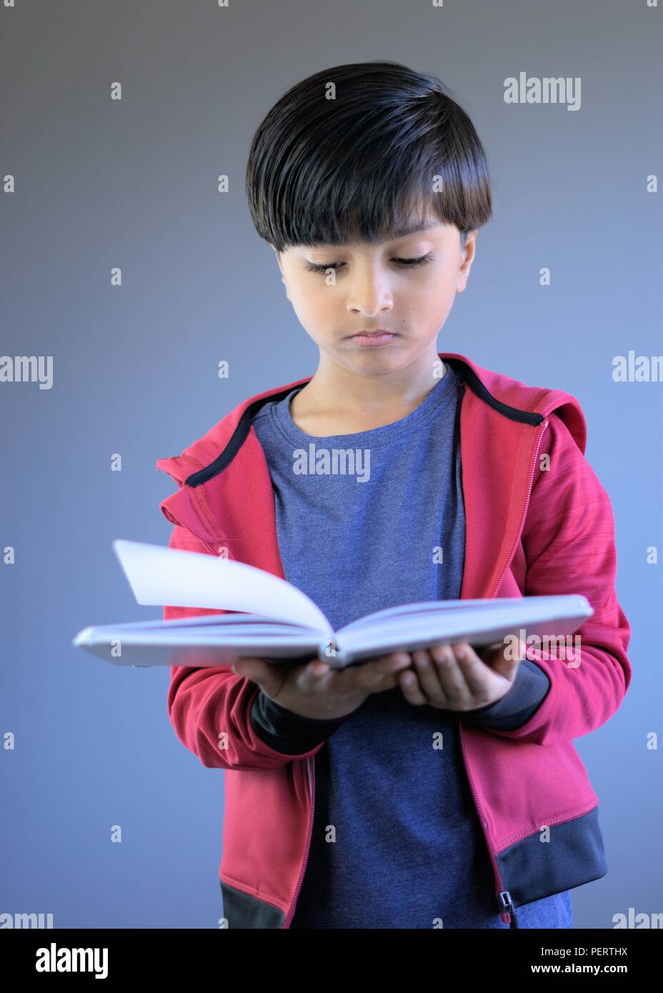 Portrait of young child reading book. Kid studying book. Stock Photo