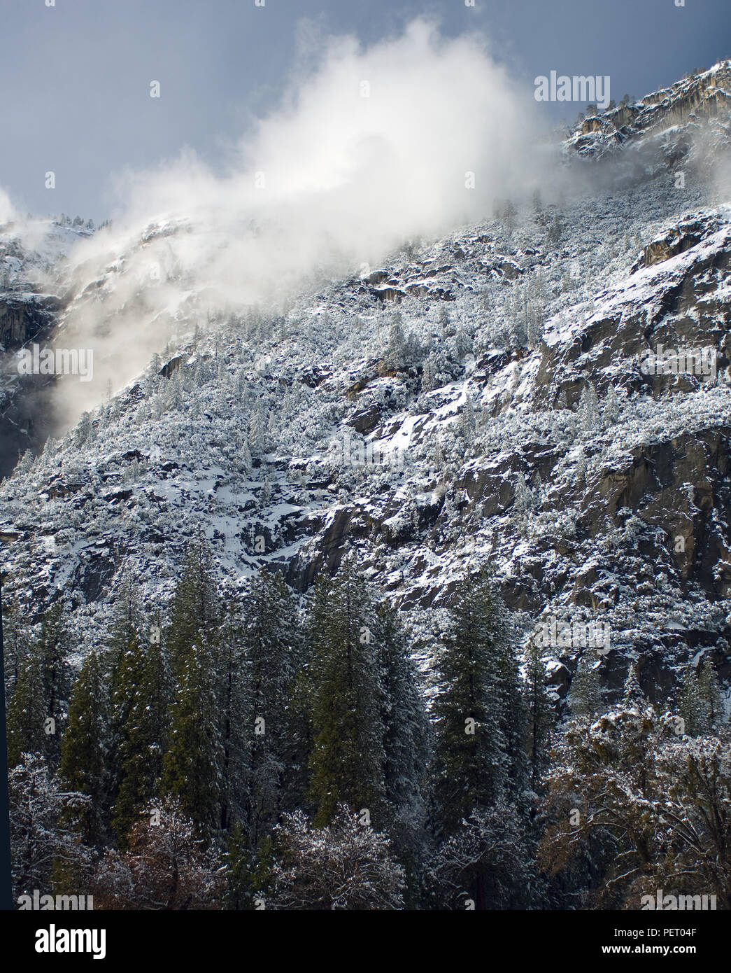 Wind kicks up a cloud of snow from the Granite rock walls surrounding ...