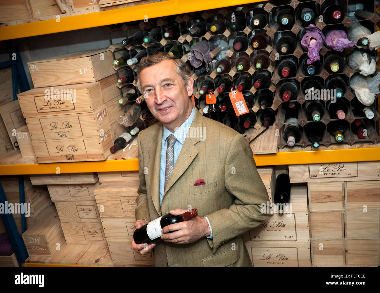 LE PIN Jacques Thienpont in his Château Le Pin wine cellar holding a bottle of renowned ‘Le Pin’ Bordeaux fine wine from appellation Pomerol France Stock Photo