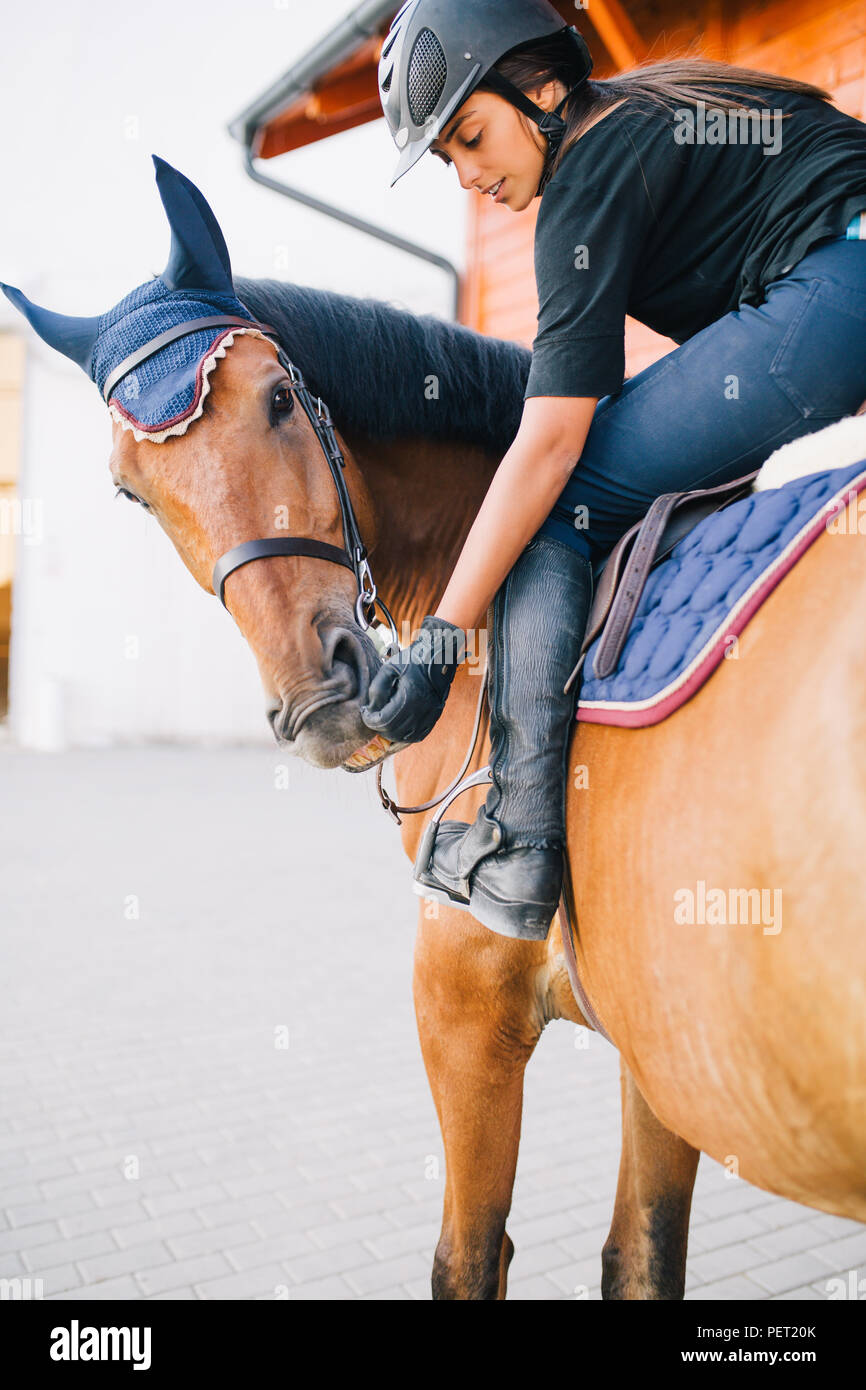 Beautiful brunette girl riding her horse Stock Photo - Alamy