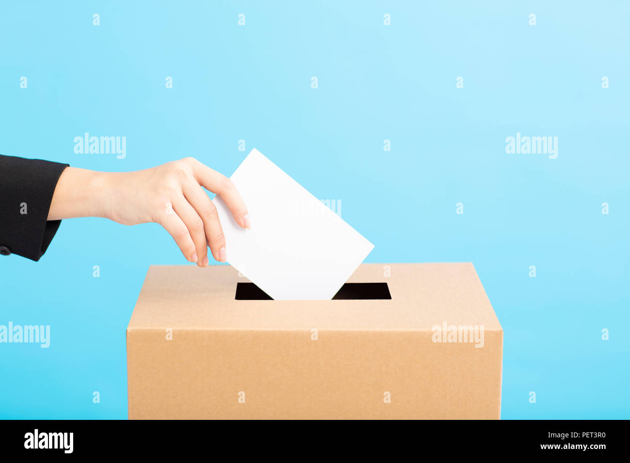 Ballot box with person casting vote on blank voting slip Stock Photo