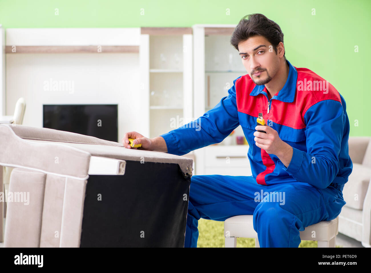 Repair contractor repairing broken furniture at home Stock Photo Alamy
