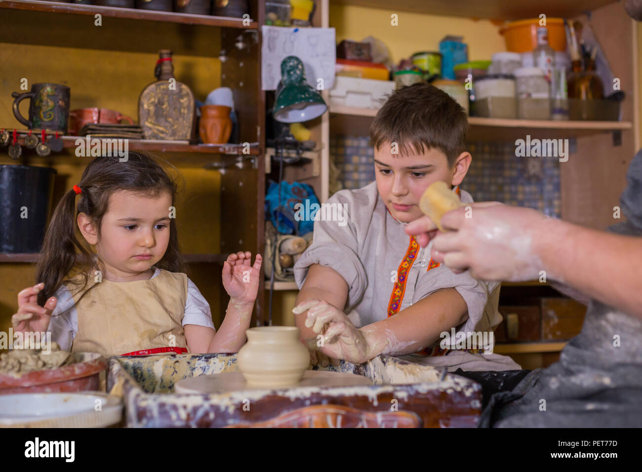 Pottery class and children trying to make ceramic wares in