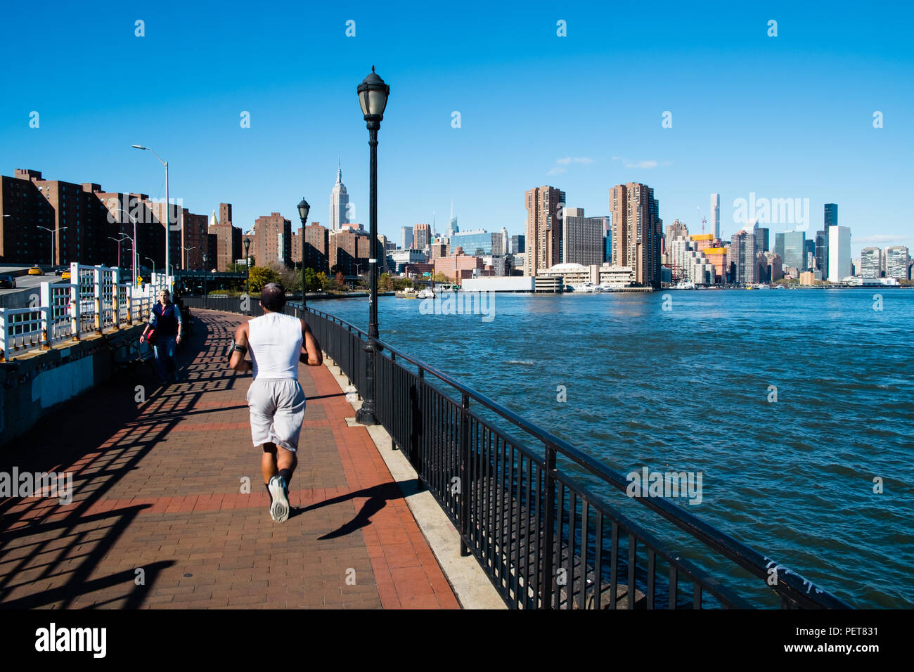 A man jogging by the river, East River, New York Stock Photo