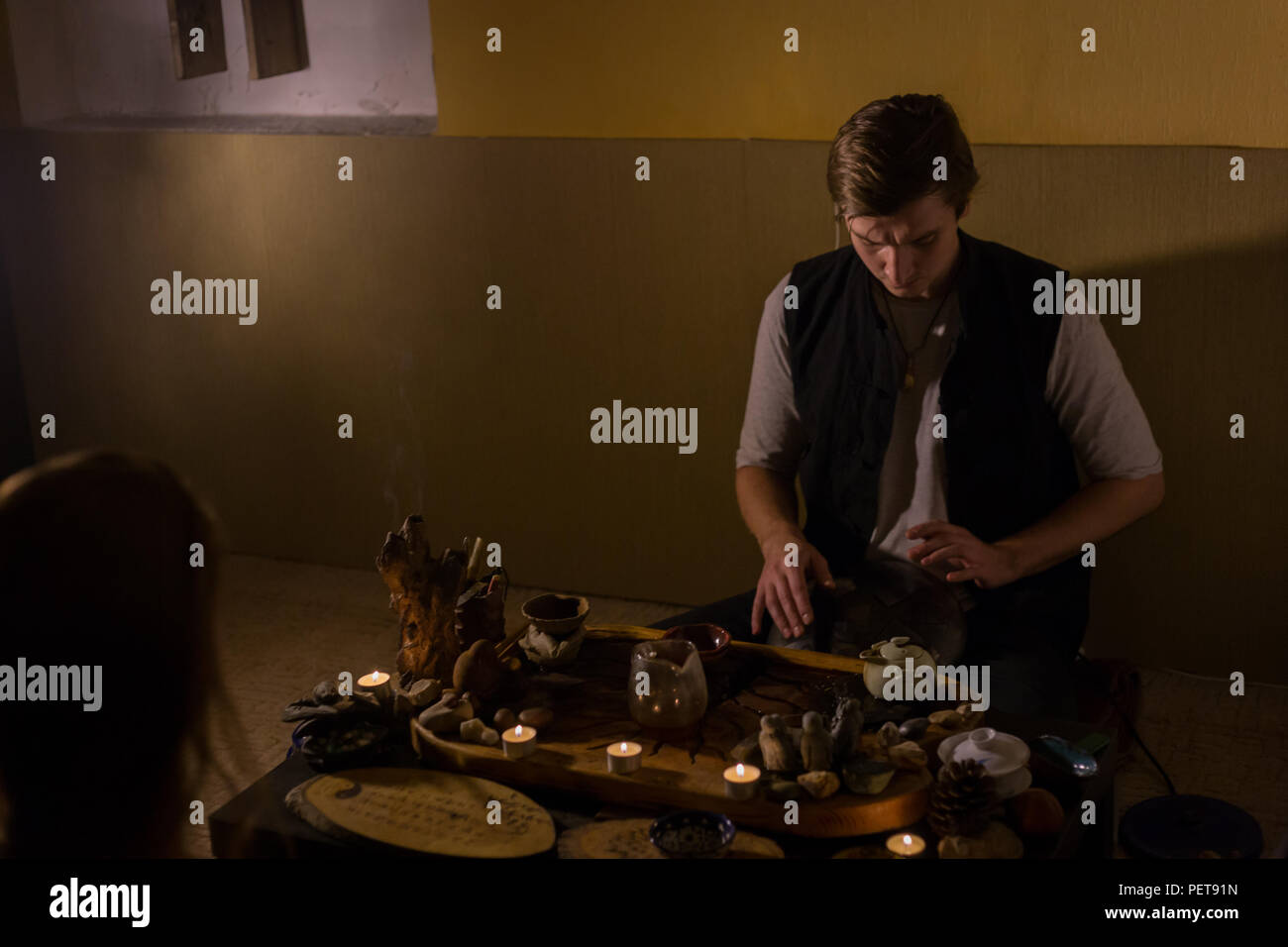 Man playing tank drum or hang at home. Warm romantic illumination, low key. Relaxation, meditative and traditional music concept. Close up shot Stock Photo