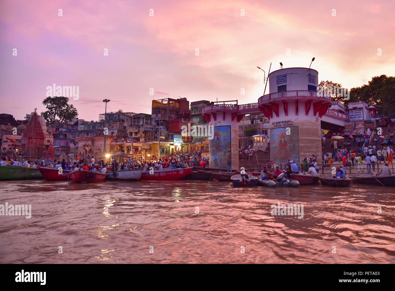 Indian people and tourists on boats at Dashashwamedh Ghat on Ganges river at evening Stock Photo