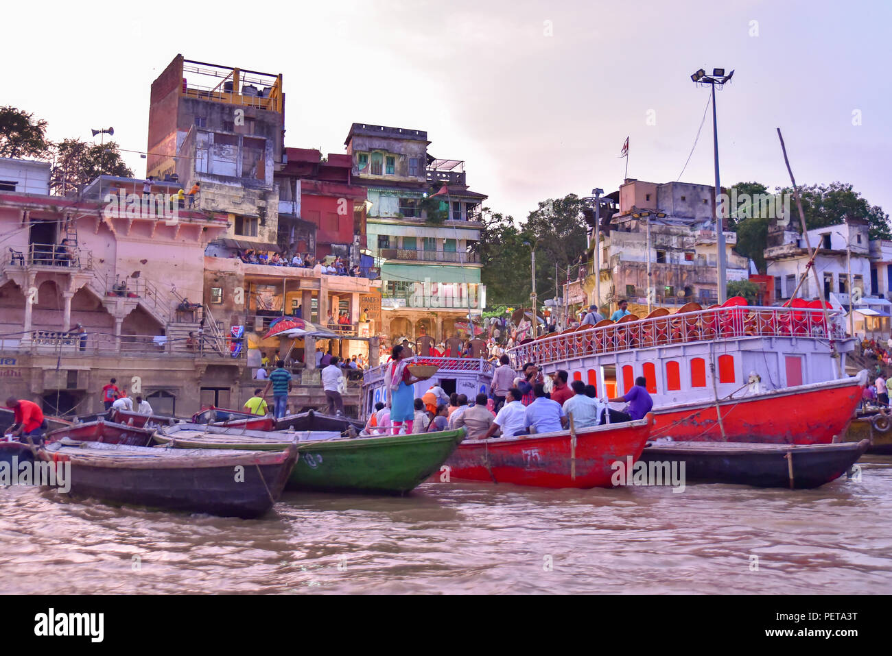 Indian people and tourists on boats at Dashashwamedh Ghat on Ganges river at evening Stock Photo