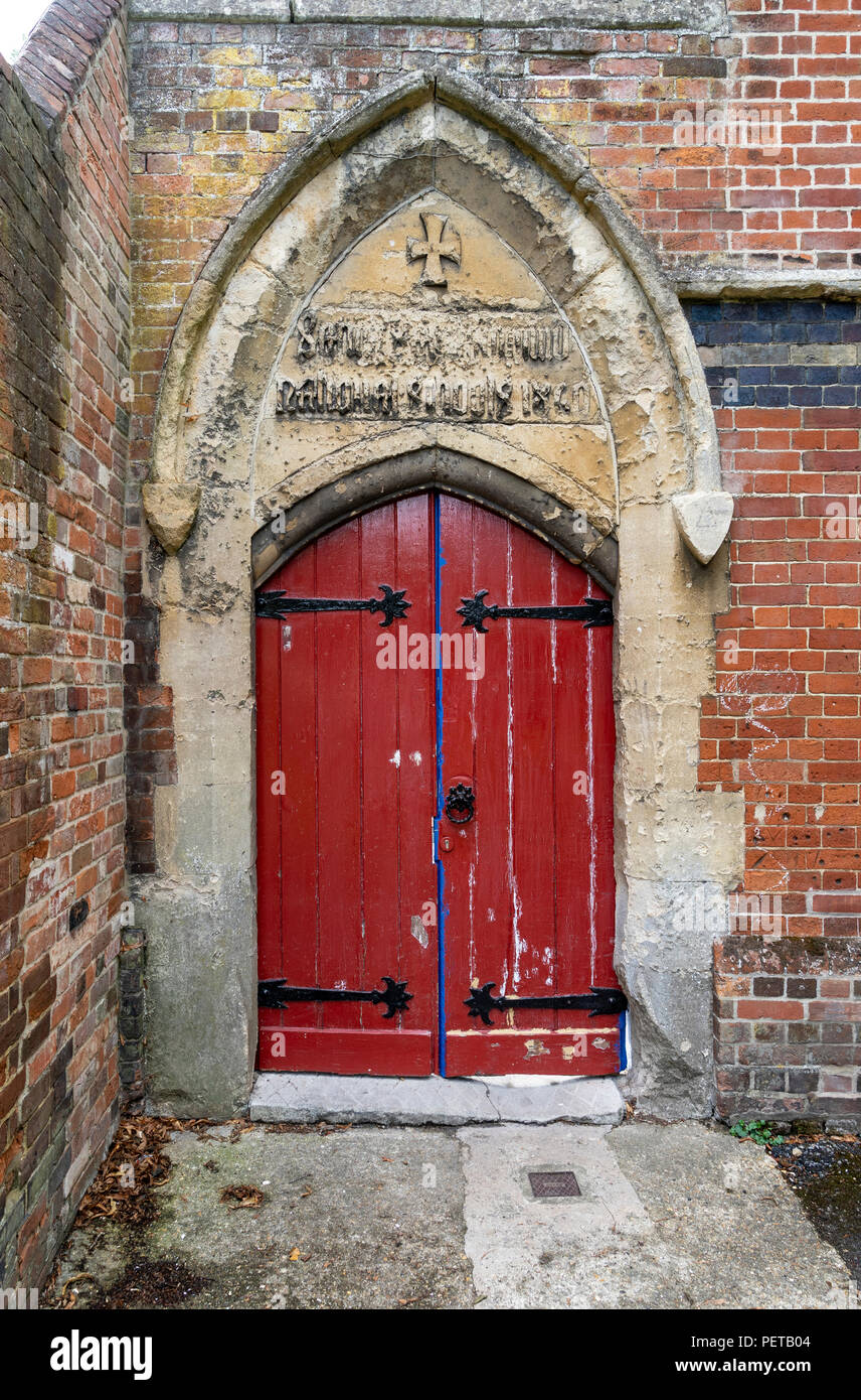 Old red double doors in stone archway Stock Photo
